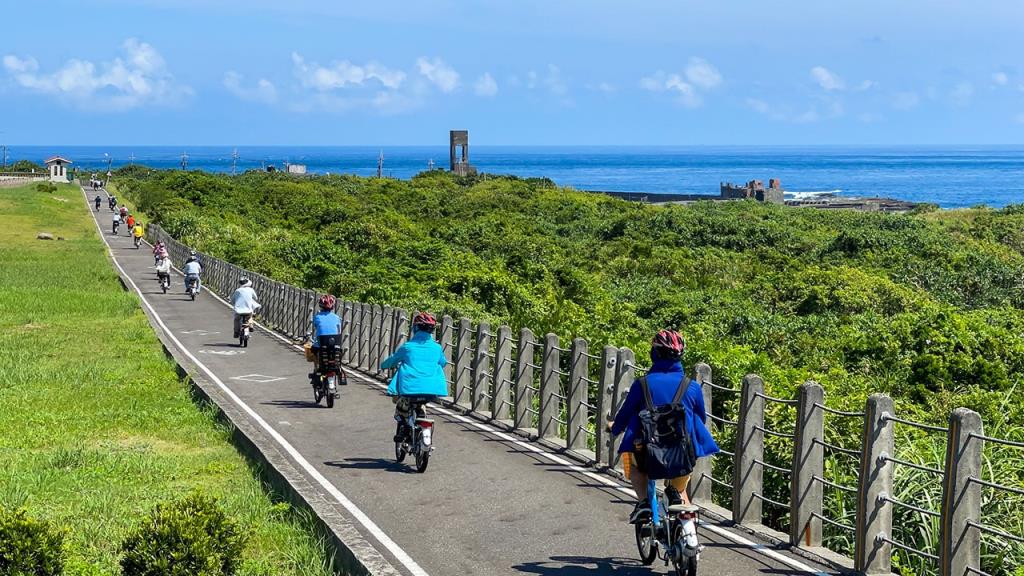 東北角自行車系列活動-一路沿著舊草嶺環狀自行車道騎乘的遊客們，欣賞著太平洋的蔚藍海景。  年度：2021  來源：東北角暨宜蘭海岸國家風景區管理處